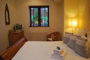 1 dormitorio con 1 cama, TV y ventana en Barn conversion near the coast en Paignton
