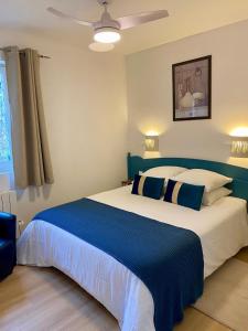 1 dormitorio con 1 cama grande con almohadas azules y blancas en Cigale de Gordes en Gordes