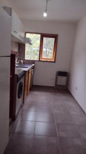 a kitchen with a stove and a window at Tan Ushuaia 2 in Ushuaia