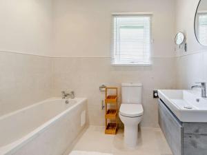 een badkamer met een bad, een toilet en een wastafel bij 3 Bed in Gower 91729 