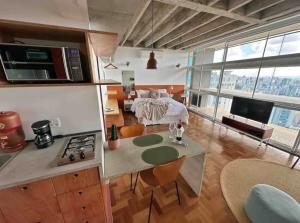 uma cozinha e sala de estar com uma cama num quarto em Vem pro Copan em São Paulo