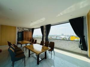 a room with two tables and chairs and a large window at Khách Sạn Metro Ban Mê in Buon Ma Thuot