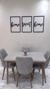 a dining room table and chairs with four pictures on the wall at Escalade BAYTI 2 in El Jadida