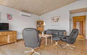 ein Wohnzimmer mit 2 Stühlen und einem TV in der Unterkunft 3 Bedroom Lovely Home In Thyholm in Thyholm