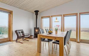 ein Esszimmer mit einem Tisch, Stühlen und Fenstern in der Unterkunft 3 Bedroom Lovely Home In Thyholm in Thyholm