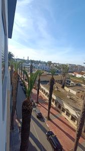 a group of palm trees in front of a building at Escalade BAYTI 2 in El Jadida