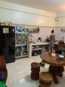 una mujer parada en una cocina preparando comida en Mondulkiri Holiday homestay en Sen Monorom