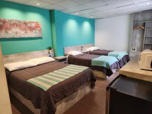 two beds in a room with green walls at PH suites in Río Cuarto