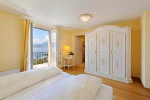 - une chambre avec une grande armoire blanche et une fenêtre dans l'établissement Seehof Hotel Du Lac, à Weggis