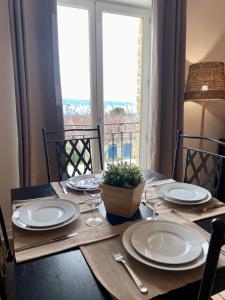 a table with plates and wine glasses and a window at Cigale de Gordes in Gordes