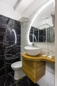 a bathroom with a sink and a toilet and a mirror at Hotel Bella Napoli in Naples