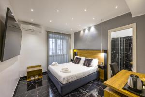 a bedroom with a bed and a desk in a room at Hotel Bella Napoli in Naples