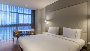 a hotel room with a large bed and a table at AC Hotel Som by Marriott in Hospitalet de Llobregat