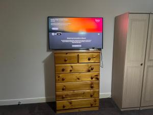 a flat screen tv sitting on top of a dresser at HAMS REST PLACE - Strictly Only ONE GUEST ALLOWED IN ONE ROOM A SECOND ACCOMPANYING PERSON WILL NOT BE ALLOWED INTO THE PROPERTY in Birmingham