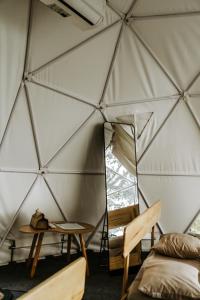 Cette chambre comprend une tente avec un lit et une table. dans l'établissement Tropical eGlamping, à Tân Phú