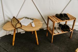 a table with a pair of shoes sitting next to a table with a tablength at Tropical eGlamping in Tân Phú