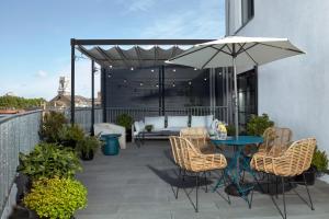 a patio with a table and chairs and an umbrella at One Hundred Shoreditch in London