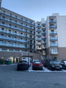 a parking lot with cars parked in front of a building at Warsaw Home Suites in Warsaw +66 photos