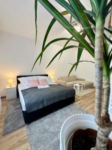 a bedroom with a bed and a palm tree at Mate Gold Apartment in Szeged