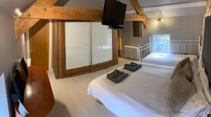 a bedroom with two beds and a flat screen tv at Winnie Cottage - Hot Tub, Games Room, Sauna, Large Garden in Stocksfield