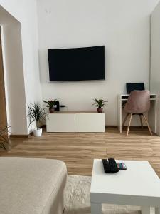 ein Wohnzimmer mit einem Flachbild-TV an der Wand in der Unterkunft Mate Gold Apartment in Szeged