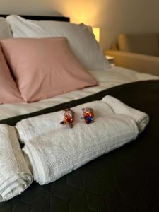 a pair of engagement rings sitting on towels on a bed at Mate Gold Apartment in Szeged