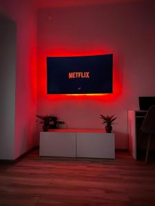 a living room with anetflix sign on a red wall at Mate Gold Apartment in Szeged
