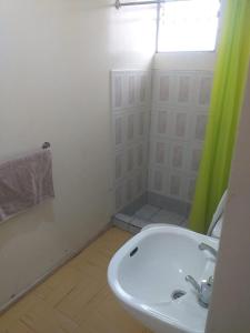 a bathroom with a sink and a shower with a window at CASA en la serena in La Serena