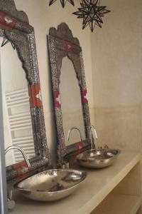 a bathroom with two sinks and two mirrors on a counter at Riad Yamcha in Meknès