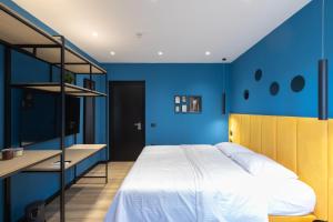 a bedroom with blue walls and a large bed at UrbanBllok5 in Tirana