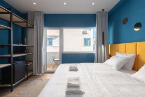 a bedroom with a large bed with a blue wall at UrbanBllok5 in Tirana