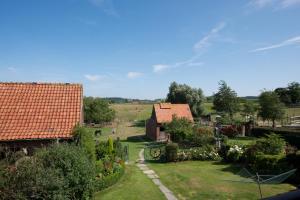 uma vista para o jardim a partir da casa em De Vitsemolenhoeve em Westouter