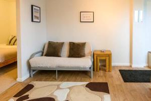 een woonkamer met een bank en een tafel bij Ellan Hay by StayStaycations in Bristol