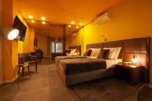 a bedroom with a large bed and a yellow wall at X Boutique Marinac Studio Apartments & Rooms in Šibenik