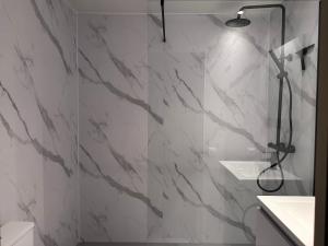 a bathroom with a shower with white marble walls at Smartflats - L'Orangerie IV Maastricht in Maastricht