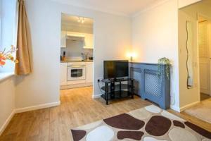 een woonkamer met een televisie en een keuken bij Ellan Hay by StayStaycations in Bristol
