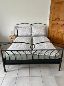 ein Bett mit einem schwarzen Metallrahmen und Kissen in der Unterkunft Bei Hempels in Breitscheid