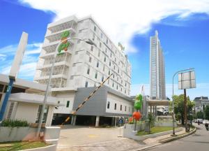 un gran edificio blanco en una calle de la ciudad en POP! Hotel Kemang Jakarta, en Yakarta