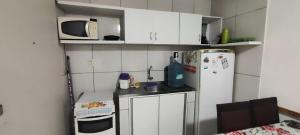 a small kitchen with a microwave and a refrigerator at Boa Vista in Recife