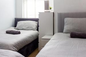 a bedroom with two beds and a nightstand between them at Beautiful 4-Bed House in Bootle in Bootle