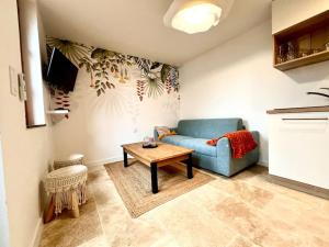 a living room with a blue couch and a table at Le Nid Arrivé autonome clim wifi linge inclus in Romorantin