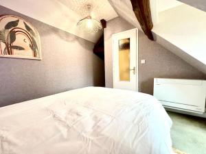 ein Schlafzimmer mit einem weißen Bett in einem Zimmer in der Unterkunft Le Nid Arrivé autonome clim wifi linge inclus in Romorantin