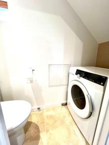 a bathroom with a washing machine and a toilet at Le Nid Arrivé autonome clim wifi linge inclus in Romorantin