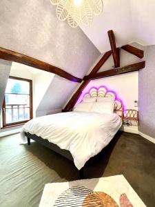 a bedroom with a white bed with purple lighting at Le Nid Arrivé autonome clim wifi linge inclus in Romorantin