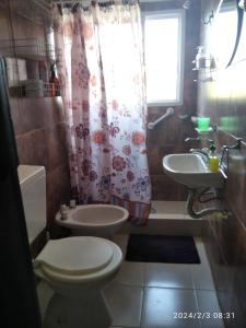 a bathroom with a toilet and a sink at Luciana G in Río Ceballos