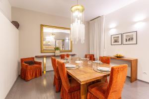 ein Esszimmer mit einem Holztisch und Stühlen in der Unterkunft Spanish Steps DeLuxe Apartment in Rom