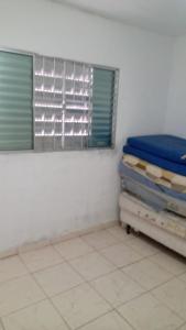 Cette chambre comprend un lit et une fenêtre. dans l'établissement Chácara nossa senhora Aparecida, à Suzano