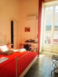 een slaapkamer met een bed, een bureau en een raam bij B&B Perla in Catania