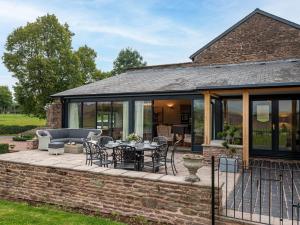 an extension of a house with a patio with a table and chairs at 4 bed in Monmouth 83768 in Saint Weonards