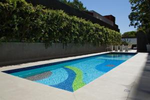 - une piscine ornée d'une mosaïque sur le côté du bâtiment dans l'établissement George V Alto De Pinheiros, à São Paulo